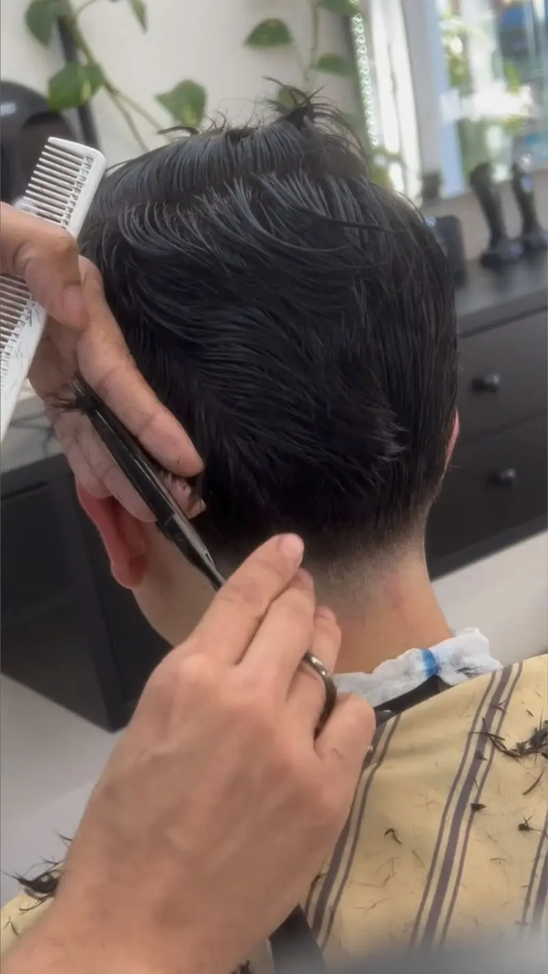 Detalhe de corte com tesoura e pente